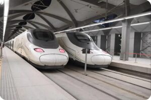 Two Haramain trains waiting beside a station platform in Saudi Arabia