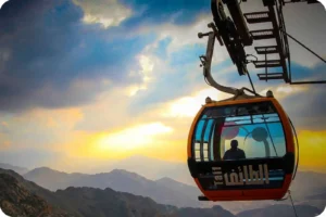 Cable car cabin suspended above a mountain landscape near Taif